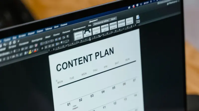 A laptop screen showing a weekly content plan calendar.
